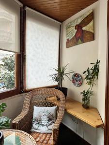 einen Korbstuhl in einem Zimmer mit einem Tisch und einem Fenster in der Unterkunft Alojamiento en el corazón de Monforte de Lemos en Ribeira Sacra in Monforte de Lemos