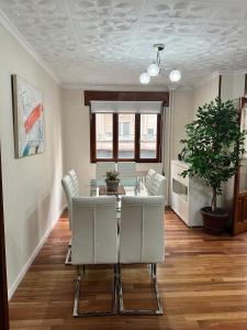 ein Esszimmer mit einem Tisch und weißen Stühlen in der Unterkunft Alojamiento en el corazón de Monforte de Lemos en Ribeira Sacra in Monforte de Lemos