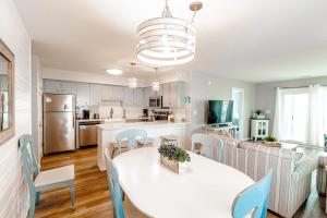 a kitchen and dining room with a white table and chairs at Oceanfront and Modern Top Location on Ocean Blvd w Pool in Myrtle Beach