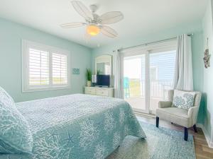 a bedroom with a bed and a fan and a chair at Oceanfront and Modern Top Location on Ocean Blvd w Pool in Myrtle Beach