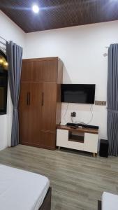 een woonkamer met een tv en een kast bij Homestay Ngõ Nhỏ 
