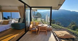 a bedroom with a bed and a table with a view at WATA KHIRI by Wang Put Tan in Mae Salong