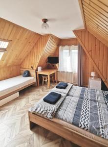 ein Schlafzimmer mit einem Bett in einem Zimmer mit Holzwänden in der Unterkunft Czarny Jeleń in Zakopane