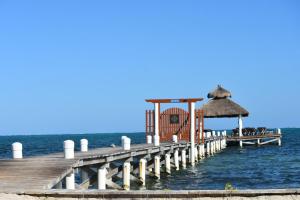 einen Pier mit einem Pavillon auf dem Wasser in der Unterkunft VeLento Beach Level #9 in Caye Caulker