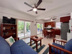 sala de estar con sofá azul y cocina en VeLento Beach Level #9, en Caye Caulker