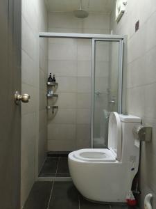 a white toilet in a bathroom with a shower at Studio 14 Vacation with Pool in Shah Alam City in Shah Alam