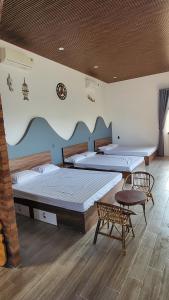een slaapkamer met 2 bedden en een tafel en een stoel bij Homestay Ngõ Nhỏ 