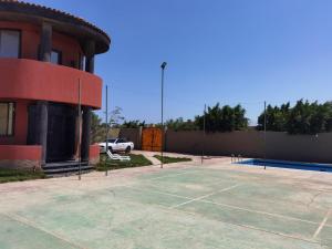 a tennis court in a parking lot next to a building at Villa Mostafa Sadek, Swimming pool, Tennis & Squash - Borg ElArab Airport Alexandria in Borg El Arab