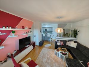 a living room with a couch and a tv at Best Location - Heart Of Tuzla in Tuzla