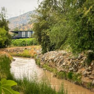 a river with a house on the side of it at Viña LOF - Maipo Valley Bed & Breakfast in Winery in Paine