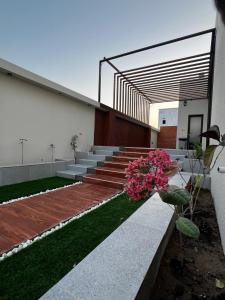 a building with stairs and flowers in a yard at شالية رواء كبلز in á¸¨arÄdÄ«