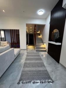 a hallway with a staircase and a rug on the floor at شالية رواء كبلز in á¸¨arÄdÄ«