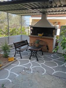 a bench sitting on a patio with a fireplace at Margaritas Cottage in Nafplio