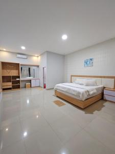 ein Schlafzimmer mit einem Bett und einem großen weißen Fliesenboden in der Unterkunft LOSMEN 88 in Ratodena