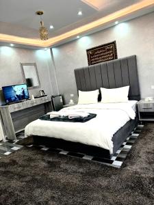 a bedroom with a large bed and a flat screen tv at Petra Pillars Hostel in Wadi Musa