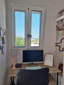 Kalo Chorio的住宿－Jasmine Summer House，电脑桌,带显示器和两个窗口