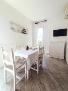 a white dining room with a white table and chairs at Residence La Meridiana in San Bartolomeo al Mare