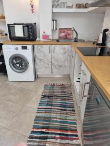 a kitchen with a washing machine and a rug on the floor at Jasmine Summer House in Kalo Chorio