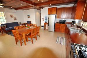 cocina y sala de estar con mesa de madera y sillas en VeLento Partial Ocean View #8, en Caye Caulker