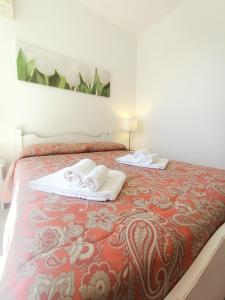 a bed with two towels on top of it at Residence La Meridiana in San Bartolomeo al Mare