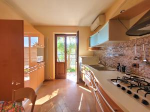 una cucina con lavandino e piano cottura forno superiore di Villa Fior di Loto a Limone sul Garda