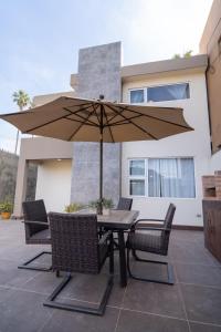 a table and chairs with an umbrella on a patio at Casa Espejos Sauzal with AC and Private Parking in El Suazal