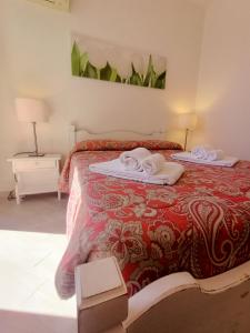 a bedroom with a bed with towels on it at Residence La Meridiana in San Bartolomeo al Mare