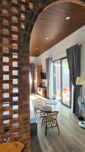 een woonkamer met een bakstenen muur en een tafel en stoelen bij Homestay Ngõ Nhỏ 