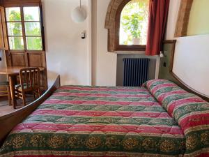 a bed in a room with a table and a window at Bed & Breakfast Casale Gregoriano and Apartaments in San Gimignano