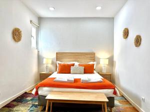 リスボンにあるBeautiful apartment in Bairro Alto - Quiteのベッドルーム1室(オレンジ色のベッド1台、ランプ2つ付)