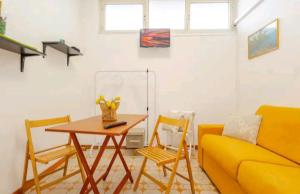 a living room with a table and chairs and a couch at Tiny house Taormina mare with sofa bed - mini stanza Taormina mare con divano letto in Taormina
