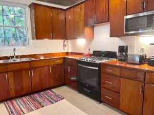 a kitchen with wooden cabinets and a stove top oven at Caribbean Beach Suite in Caye Caulker