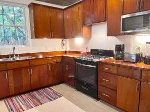 una cucina con mobili in legno e un forno a piano cottura di Caribbean Beach Suite a Caye Caulker