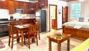 a kitchen with a table and a kitchen with a bed at Caribbean Beach Suite in Caye Caulker