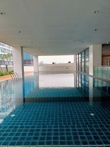 a swimming pool with blue tile flooring in a building at Studio 14 Vacation with Pool in Shah Alam City in Shah Alam