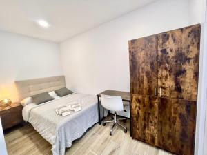 um quarto com uma cama e uma secretária com uma cadeira em Hospedaje24 - 0 em Manresa