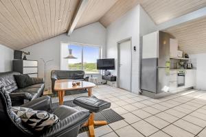 uma sala de estar com sofás e uma mesa e uma cozinha em Holiday home with spa and pool by the sea - SJ670 em Harboør
