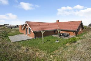 una casa con una terraza al lado de un campo en Holiday home with spa and pool by the sea - SJ670 en Harboør