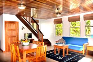 a living room with a blue couch and a table at Caribbean Sunrise Cottage in Caye Caulker