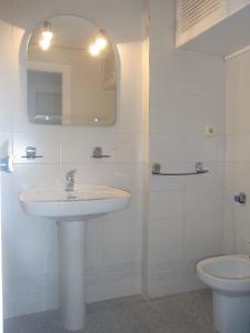 Baño blanco con lavabo y aseo en Residencial Los Ibicencos V.v., en La Manga del Mar Menor