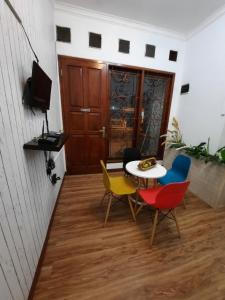 Cette chambre dispose d'une table, de chaises et d'une télévision. dans l'établissement WISMA ACIDALIA SYARIAH, à Bandung