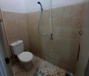 La salle de bains est pourvue d'une douche et de toilettes. dans l'établissement WISMA ACIDALIA SYARIAH, à Bandung