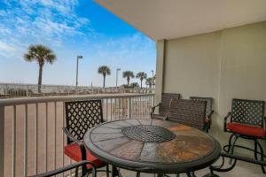 a table and chairs on a balcony with a view of the beach at Tradewinds 001 by Vacation Homes Collection in Orange Beach