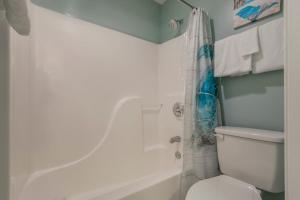 a bathroom with a white toilet and a shower at Tradewinds 001 by Vacation Homes Collection in Orange Beach