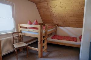 - une chambre avec 2 lits superposés et une chaise dans l'établissement Ferienhaus Ziegler, à Loßburg