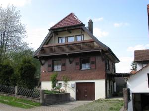 une maison avec un toit marron et un garage blanc dans l'établissement Ferienhaus Ziegler, à Loßburg
