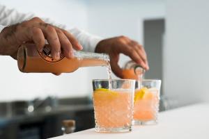 a person pouring a drink into a glass at Rodi Resort in Rodi Garganico