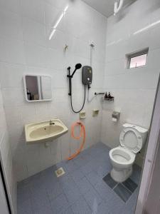 ein weißes Bad mit einem WC und einem Waschbecken in der Unterkunft 3Homestay Bentong in Bentong