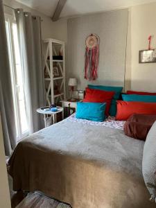 グリモーにあるLes Restanquesのベッドルーム1室(青と赤の枕が備わるベッド1台付)