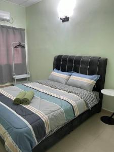 Bett mit schwarzem Kopfteil in einem Zimmer in der Unterkunft 3Homestay Bentong in Bentong